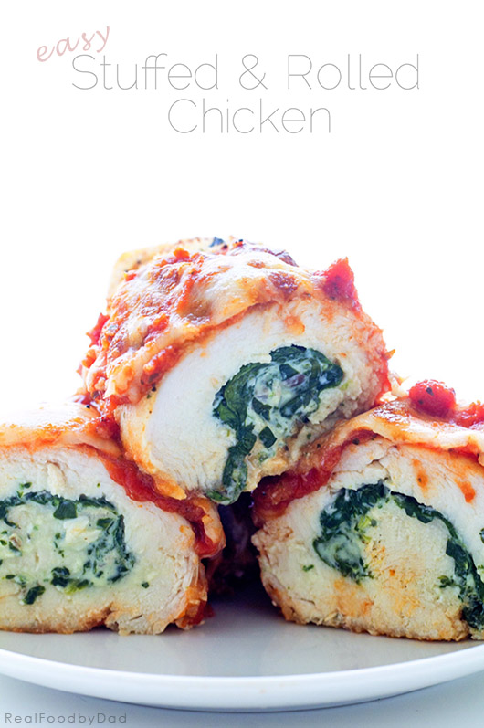 Three stuffed chicken rolls stacked into a pyramid shape on a plate.